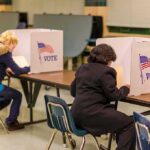 Hudson Valley Race Draws National Spotlight Voters seated at booths filling out ballots in a polling place