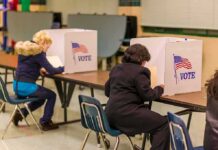 Hudson Valley Race Draws National Spotlight Voters seated at booths filling out ballots in a polling place