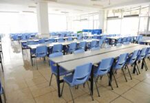 Donor-Driven Dollars Reshape Classrooms Empty cafeteria with rows of blue chairs and long tables