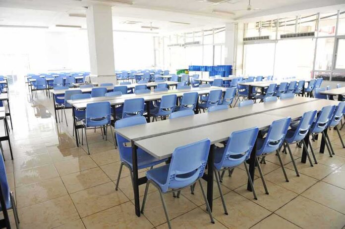 shutterstock_106081136 Empty cafeteria with rows of blue chairs and long tables