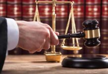 Killer Cadillac Mystery Grips Tupac Trial Judge's hand holding gavel near scales of justice