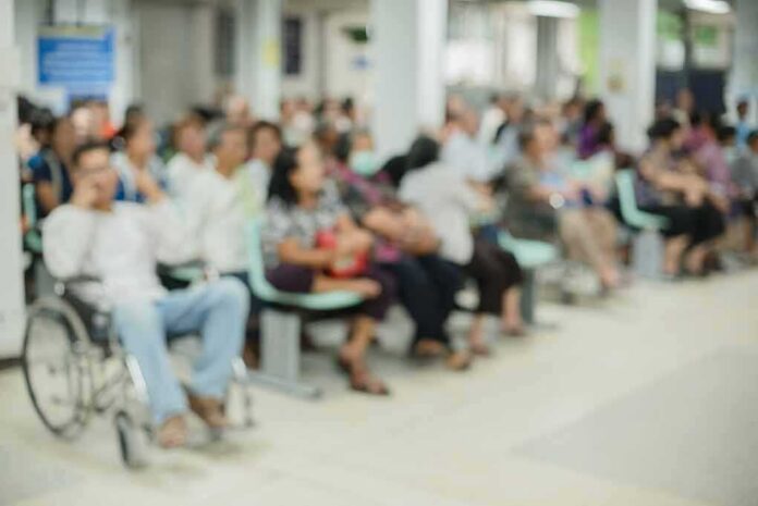shutterstock_1118873060 Crowd of people waiting in a hospital waiting area