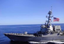 Navy’s $13 Billion Carrier Gamble Resurfaces Naval destroyer sailing on open sea with flag flying