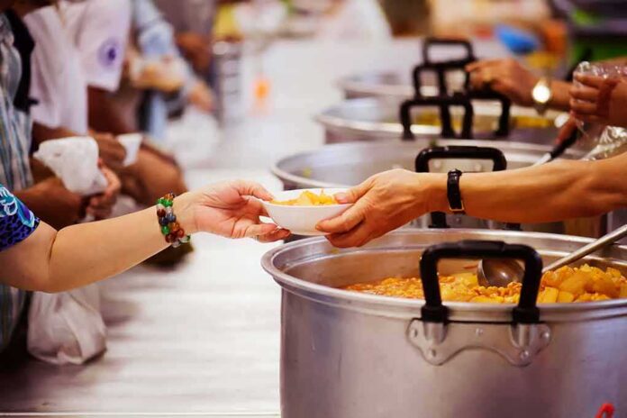 shutterstock_1218132919 Hands serving soup at a community kitchen