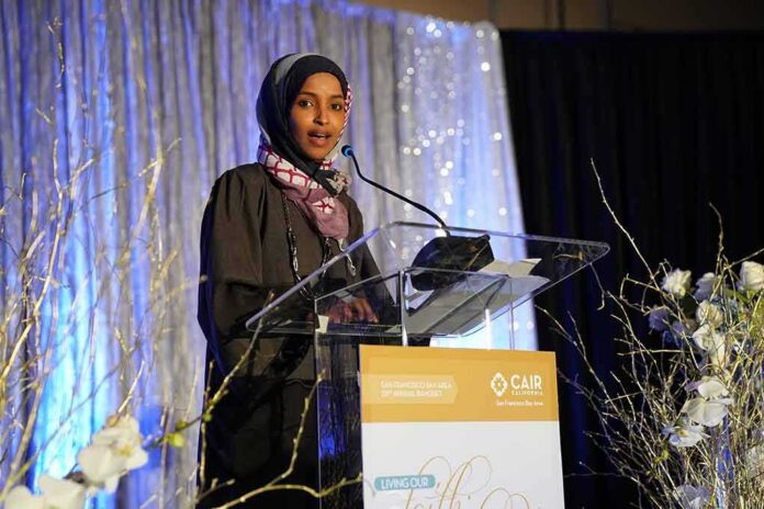shutterstock_1311573101 Woman in hijab speaking at a podium on a decorated stage