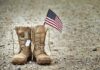 New Pell Hack Delivers Big For Fallen Heroes Combat boots with dog tags and a small American flag on gravel