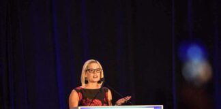Woman speaking at a podium on a stage