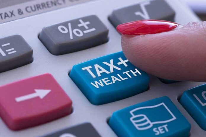 shutterstock_1762066592 finger pressing tax button on calculator