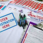 Ballot Brawl Explodes Over SAVE Act Voter registration table with forms, pens, and informational materials