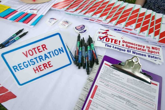 shutterstock_177445370 Voter registration table with forms, pens, and informational materials
