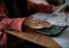 Financial Stress Remains Alarmingly High Person using a calculator with bills on a desk