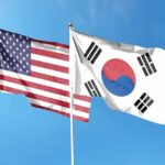 United States and South Korea flags waving against a clear blue sky