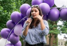AOC’s Bold Move Rattles 2028 Field Woman speaking into a microphone at an outdoor event with purple balloons