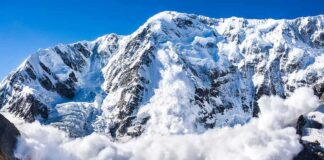 Snow avalanche sweeping down a rugged mountain