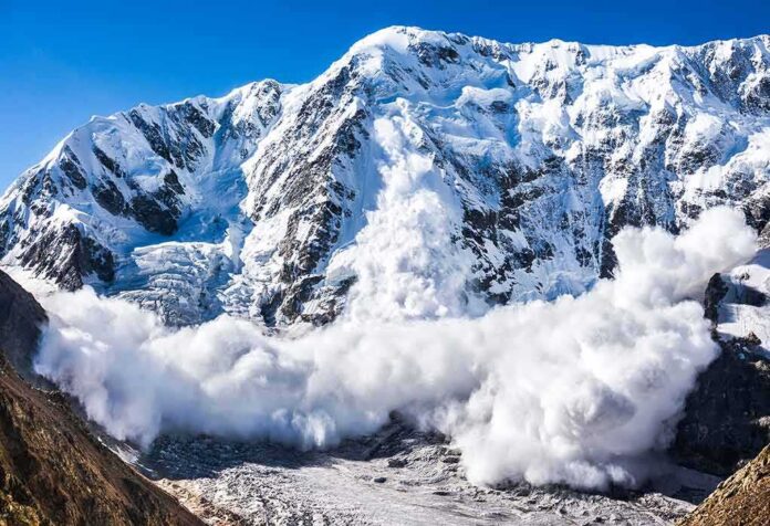 shutterstock_491923291 Snow avalanche sweeping down a rugged mountain