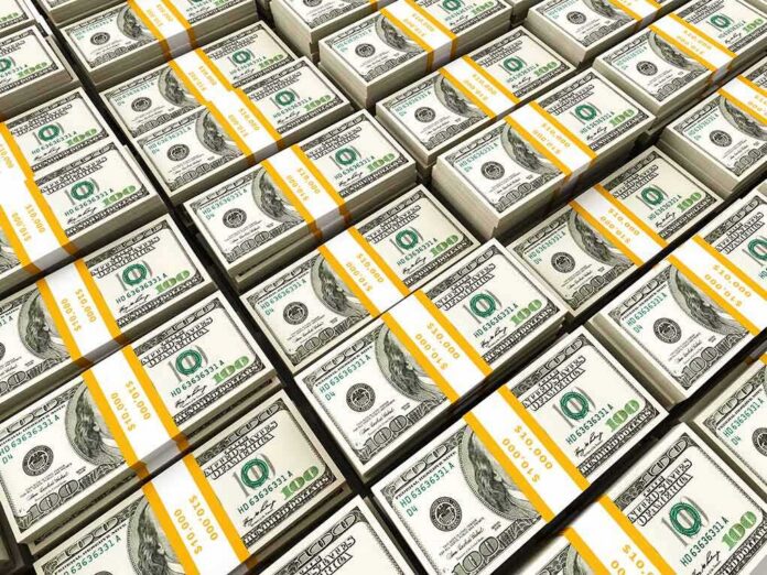 shutterstock_97543529 Stacks of US hundred-dollar bills bundled with yellow straps