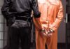 Ohio Defendant SNAPS, Chaos Erupts Prisoner in orange jumpsuit handcuffed with guard standing beside
