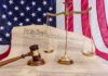 Chief Justice’s Past Draws Attention Scales of justice and gavel on the U.S. Constitution with American flag backdrop