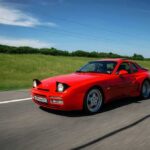 Red sports car driving on a rural highway
