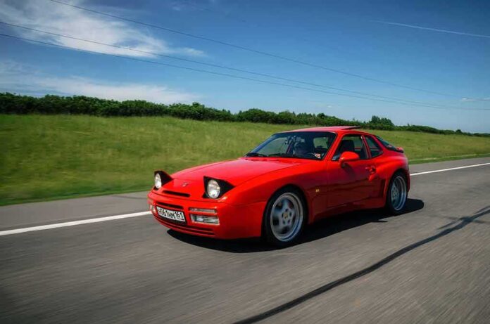 shutterstock_1100732141 Red sports car driving on a rural highway