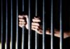 Judge Orders Force-Feeding For Accused Killer hands gripping prison bars
