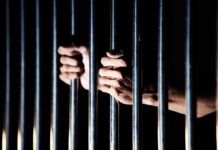 Judge Orders Force-Feeding For Accused Killer hands gripping prison bars