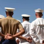 sailors and marines standing in formation with hands behind backs