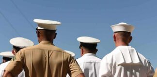 sailors and marines standing in formation with hands behind backs
