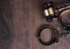 Judge’s gavel and metal handcuffs on wooden table
