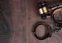 Ex-Cop Slapped With TRIPLE Life Judge’s gavel and metal handcuffs on wooden table