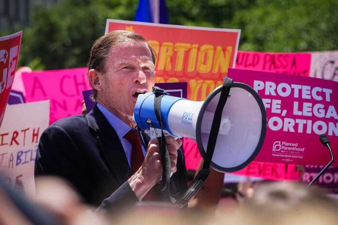 shutterstock_1403986421 Man speaking into a megaphone at a rally