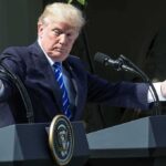 Michigan Shockwave Rattles Democrats Donald Trump speaking at dual podiums with arms outstretched