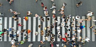 Crowd of pedestrians crossing a zebra crosswalk from above