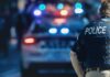 Counter-Terror Cordon Around US Air Hub police officer in vest near patrol car with flashing lights