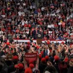 All-In Trump Move Stuns Dallas Speaker at podium addressing large crowd in arena
