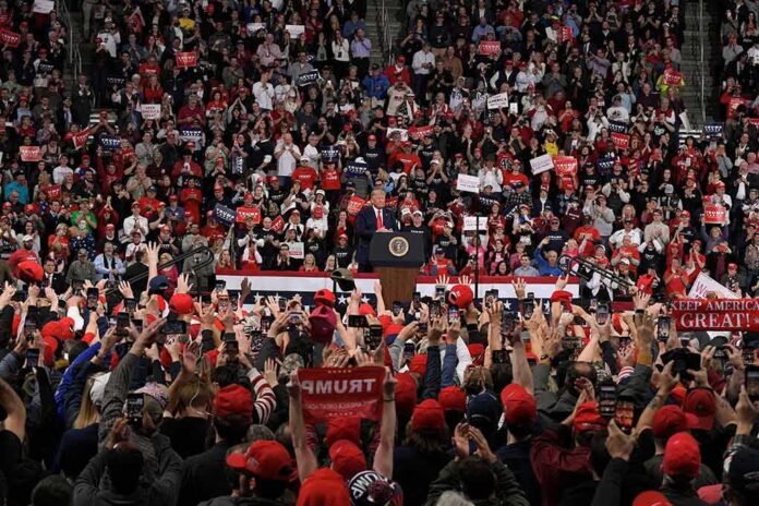 shutterstock_1585395160 Speaker at podium addressing large crowd in arena