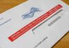Supreme Court Keeps USPS Ballot Rule Blocked Mail-in ballot envelope with red label on wooden table