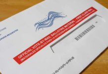 Supreme Court Keeps USPS Ballot Rule Blocked Mail-in ballot envelope with red label on wooden table