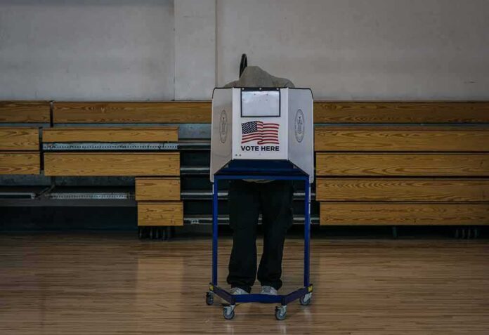 shutterstock_1846768879 Voter at a polling booth in a gymnasium