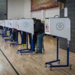 The Michigan Ad Battle Escalates Voters at polling booths in a gymnasium