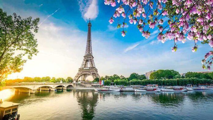 shutterstock_1933253495 Eiffel Tower by the Seine with boats and spring blossoms