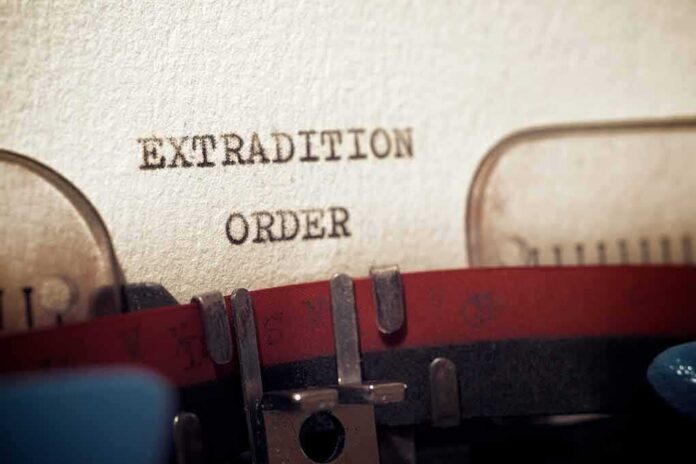 shutterstock_1964071759 Typewriter typing extradition order on paper