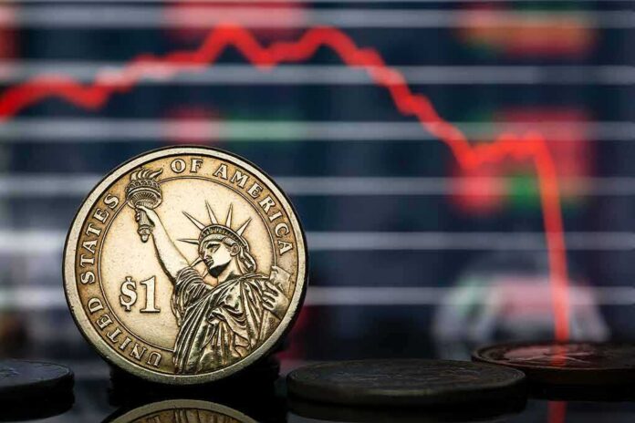 shutterstock_2132766343 U.S. dollar coin in front of falling stock chart