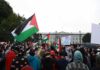 Flag Protest Interrupts Yankees-Mets At 9:11 Crowd holding flags and signs outside a fenced government building