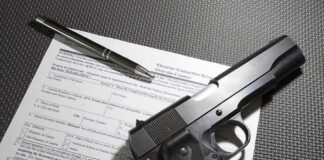 Handgun on firearm transaction form with pen