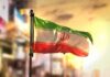 Silent Spills Threaten Iran’s Breadbasket Iranian flag waving on a pole at sunset