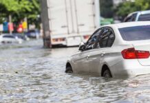 Bangkok Sinks: Entire City Declared Disaster Silver car partially submerged in floodwater