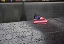 9/11 Memorial Desecrated – Sickening American flag on a rainy memorial nameplate.