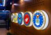 Teen Sues Marine Corps Over Alleged Assault Military department seals displayed on a wall
