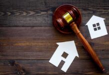 Housing Cash Mystery Rattles City Hall Judge's gavel with paper house cutouts on wooden table